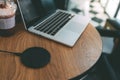 Charging mobile phone battery with wireless charging device in the table. Smartphone charging on a charging pad. Mobile phone near Royalty Free Stock Photo