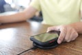 Charging mobile phone battery with wireless charging device in the table. Smartphone charging on a charging pad. Mobile phone near Royalty Free Stock Photo