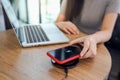 Charging mobile phone battery with wireless device in the table. Smartphone charging on a charging pad. Mobile phone near wireless Royalty Free Stock Photo