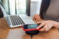 Charging mobile phone battery with wireless charging device in the table. Smartphone charging on a charging pad. Mobile phone near Royalty Free Stock Photo