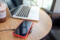 Charging mobile phone battery with wireless device in the table. Smartphone charging on a charging pad. Mobile phone near wireless Royalty Free Stock Photo