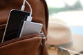 Charging mobile phone with power bank in backpack, closeup. Space for text Royalty Free Stock Photo