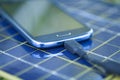 Charging mobile phone with solar charger Royalty Free Stock Photo