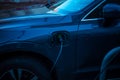 Charging a modern electric car on the street in the evening, which are the future of the Automobile Royalty Free Stock Photo
