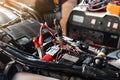 Charging motorcycle battery at garage, selective focus on Alligator clip ,concept of motorcycle maintenance and repair