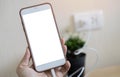 Charging a smartphone via a USB cable on woman hand. Close up of a white smartphone with a white blank screen Royalty Free Stock Photo