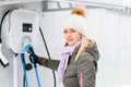 charging station, ecological fuel concept. Portrait of a beautiful young girl holding a charging plug in her modern