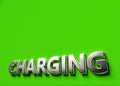 Charging word as 3D sign or logo concept placed on green surface with copy space above it. New charging technologies concept. 3D Royalty Free Stock Photo