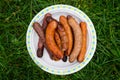 Chargrilled sausages piled on a plate Royalty Free Stock Photo