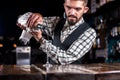 Portrait of barman creates a cocktail at the bar counter