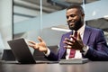 Charismatic black CEO having business conference, using laptop Royalty Free Stock Photo