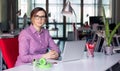 Charismatic Business Lady in casual clothing sitting at Office Table Royalty Free Stock Photo