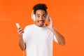 Charismatic excited, happy smiling african-american man with afro haircut, moustache, enjoying music in earphones, touch Royalty Free Stock Photo