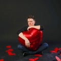 Charismatic guy holds a heart balloon inflatable in lipstick face Valentine symbol, flirting, on the floor hearts