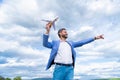 charismatic happy business man in jacket hold toy plane on sky background, idea