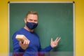 Charismatic male teacher smiling behind face mask