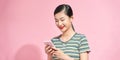 Charismatic pretty girl smiling and looking mobile phone screen as texting