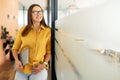 Charismatic smiling positive businesswoman stands with laptop computer at office hall, confident small business owner Royalty Free Stock Photo