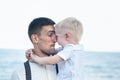 Charismatic young dad with a small son. Child hugs daddy. Father`s love fatherhood