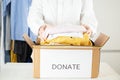 Charity and assistance to the poor, homeless, and needy, volunteer woman puts clothes in a donation box