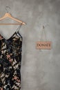 Charity concept - blackboard with text Donate and beautiful dress in floral pattern on a hanger Royalty Free Stock Photo