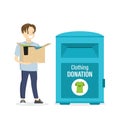 Charity donation concept banner. Caucasian boy volunteer holds box with clothes and things. Male character near big clothing