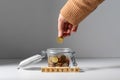 hand putting coin into jar and making donation