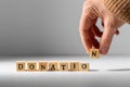 hand making donation word with wooden toy blocks