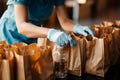 Charity gesture: High-angle view captures person filling donation bags with water altruistically.