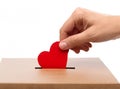 Hand putting red heart into charity donation box Royalty Free Stock Photo