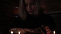 Charlatan witch reading book of black magic, view on burning candle. magic ritual