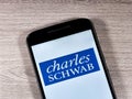 Charles Schwab logo on phone screen.