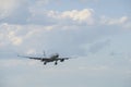 Airplane descends from sky onto runway.