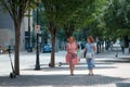 Charlotte, North Carolina, USA - August 24, 2021: Two women in brightly colored clothing walk and talk on Tryon Street in uptown