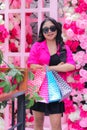 Women asian beautiful in pink shirt wearing glasses happy hand carrying debit card, smartphone and paperbag in outdoor