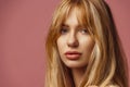 Close-up face of young beautiful tanned woman looking at camera isolated over colored studio background. Natural beauty Royalty Free Stock Photo