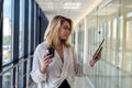 Charm young businesswoman holding digital tablet standing in corridor of a modern business center