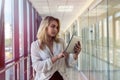 Charm young businesswoman holding digital tablet standing in corridor of a modern business center