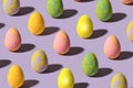 Charming abstract easter minimal concept. Lovely broken pattern made of unique colored eggs against purple background Royalty Free Stock Photo