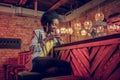 Charming African-American female delightedly enjoying coffee taste being at bar Royalty Free Stock Photo