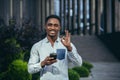 Charming african american man happy looking at camera, holding mobile phone in hands smiling and happy Royalty Free Stock Photo