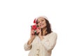 Charming African American woman wearing Santa hat and beige sweater, hugging her Christmas present over white background Royalty Free Stock Photo