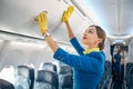 Charming air hostess learning closing compartment with hand luggage Royalty Free Stock Photo