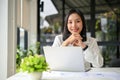 Charming Asian businesswoman or female accountant sits at her desk in her modern office Royalty Free Stock Photo