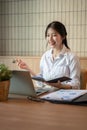 A charming Asian businesswoman is having an online meeting with her team, discussing a project Royalty Free Stock Photo