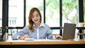 Charming Asian businesswoman managing her sales report and working at her office desk Royalty Free Stock Photo