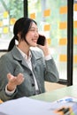 Charming Asian businesswoman talking on phone, having a good conversation through a call Royalty Free Stock Photo