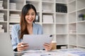 Charming Asian businesswoman using her digital tablet at her desk in the office Royalty Free Stock Photo