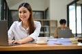 Charming Asian businesswoman working at her desk in the office, using laptop Royalty Free Stock Photo