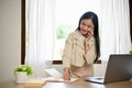 Charming Asian female business employee or secretary talking on the phone Royalty Free Stock Photo